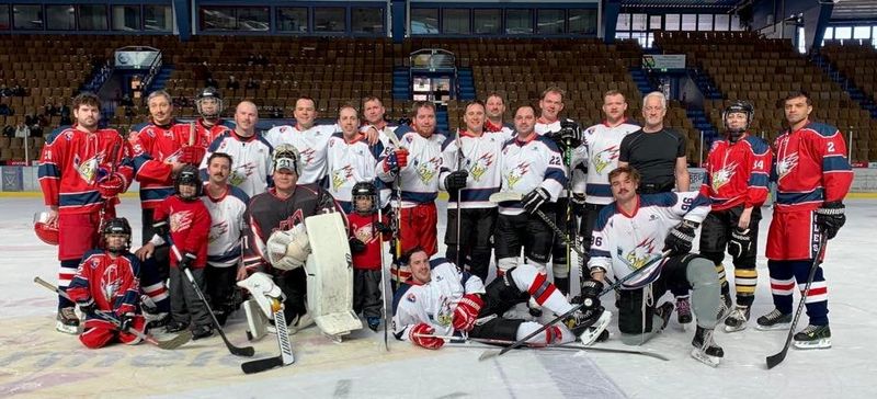KMC Eagles players in red, white and blue jerseys posing together on the ice in Garmisch-Partenkirchen